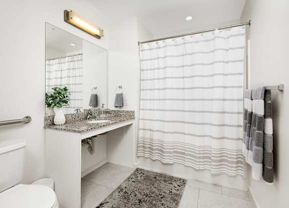 a bathroom with a shower and a sink and a toilet