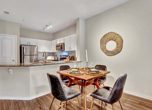 A kitchen with a dining table and chairs.