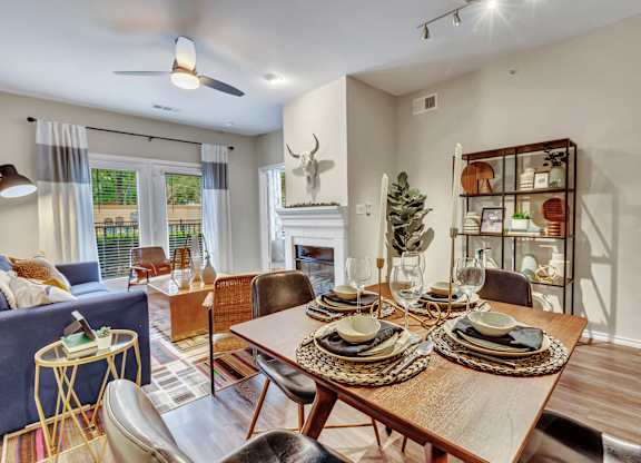 A dining room with a wooden table set for a meal.