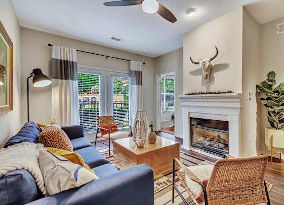 A living room with a blue couch and a fireplace.