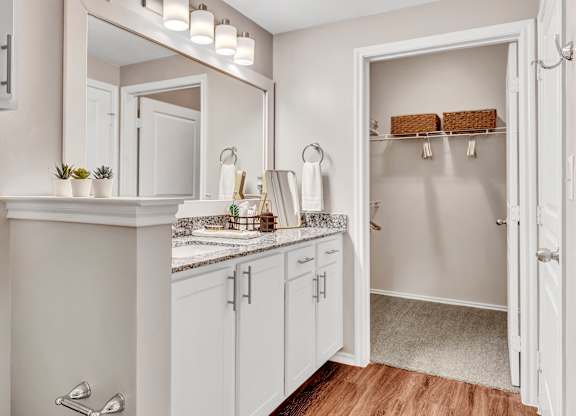 A bathroom with a white cabinet and a mirror above the sink.