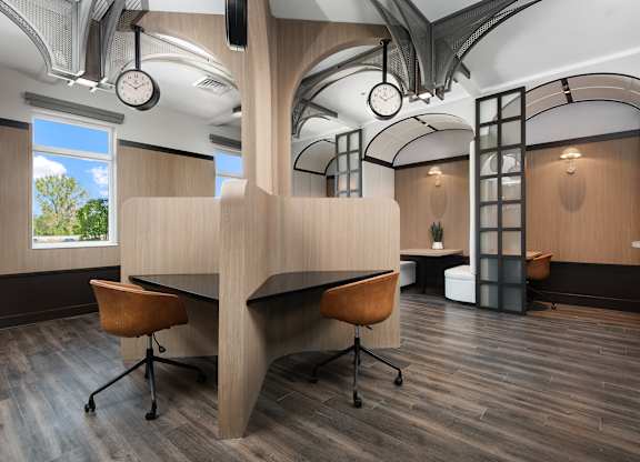 A modern office space with a curved desk and chairs.