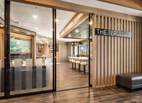 The Terminal is a stylish and modern space with a wooden floor and a glass door.