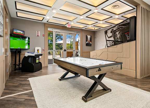 A room with a pool table and a television.