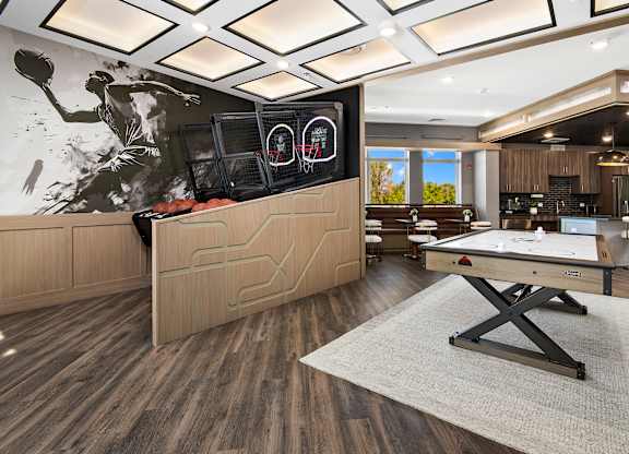 A room with a pool table and a large screen on the wall.