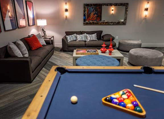 A pool table with a white ball and a triangle of balls on it.