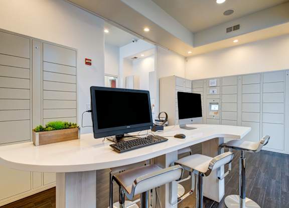 A modern office with a white desk and two monitors.