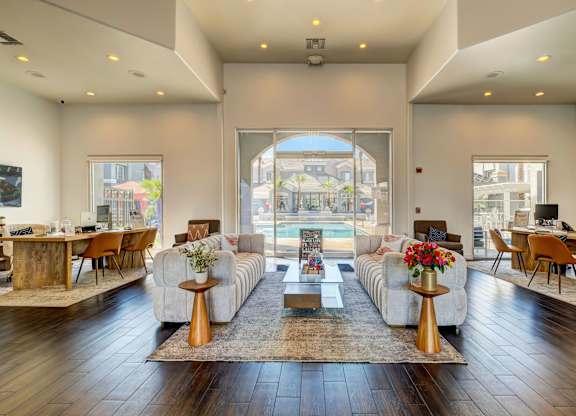 A living room with a large window and a view of the city.