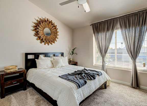 A bedroom with a large bed and a mirror on the wall.