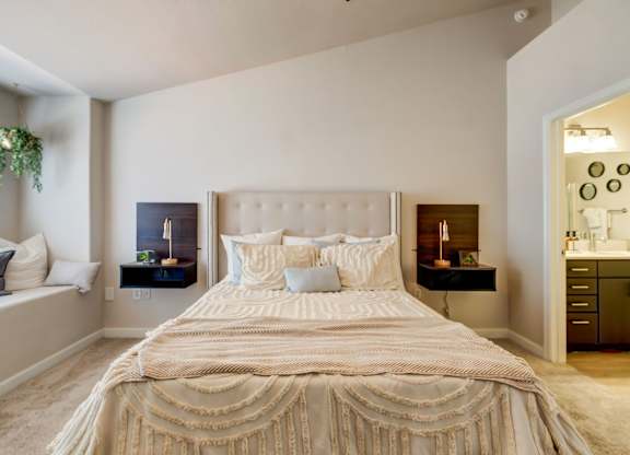 A bed with a white comforter and pillows in a bedroom.