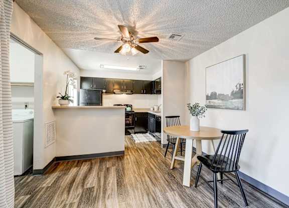A kitchen area with a dining table and chairs.