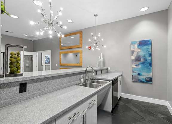 A modern kitchen with a large island and a chandelier.