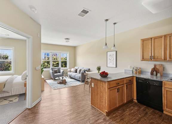 A kitchen with wooden cabinets and a black dishwasher.