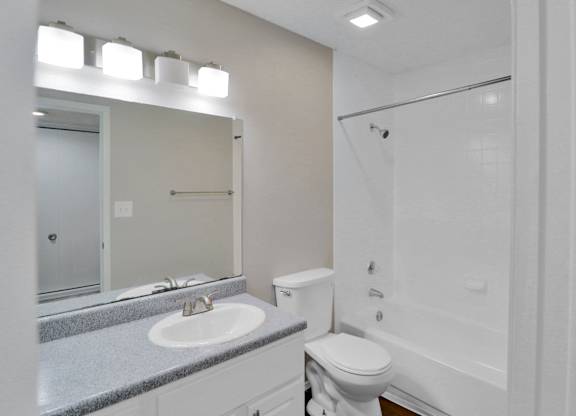 A white toilet sits next to a sink in a bathroom.