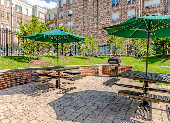 Apartments for Rent in Camp Springs, MD - Tribeca at Camp Springs - A patio with a table and chairs and umbrellas