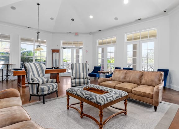 A living room with a brown sofa and striped chairs.