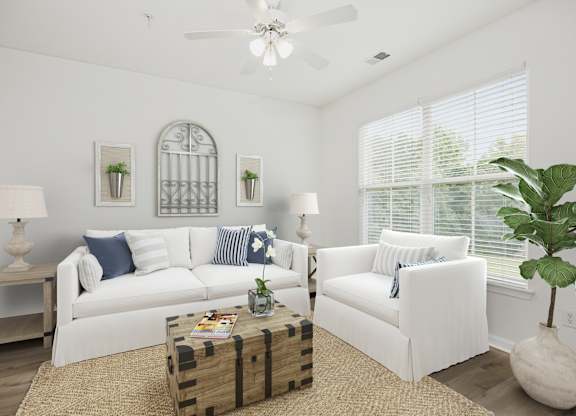 A living room with white furniture and a ceiling fan.