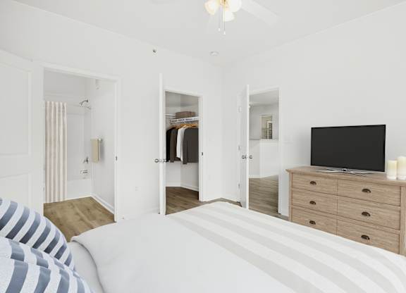 A bedroom with a bed, dresser, and mirror.