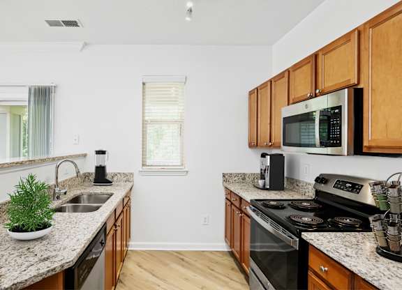 A kitchen with wooden cabinets and granite countertops.