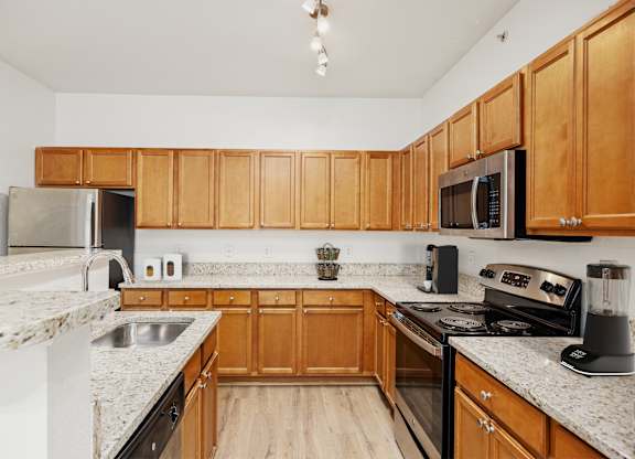 A kitchen with wooden cabinets and granite countertops.