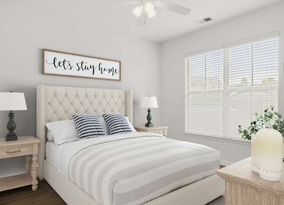 A bedroom with a bed, nightstands, and a ceiling fan.