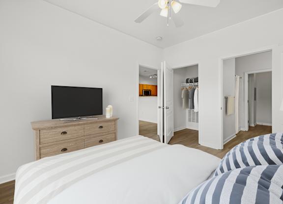 A bedroom with a bed, dresser, and a television.