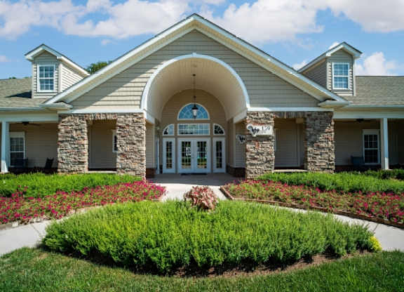 A building with a stone archway entrance and a landscaped front yard.