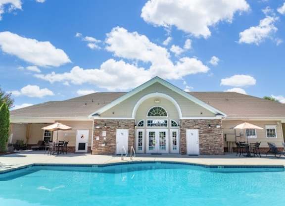 A house with a pool in front of it.