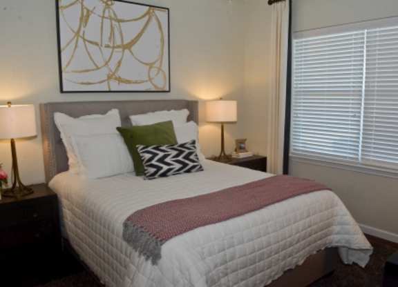 A bed with a white comforter and a red blanket is in the image.