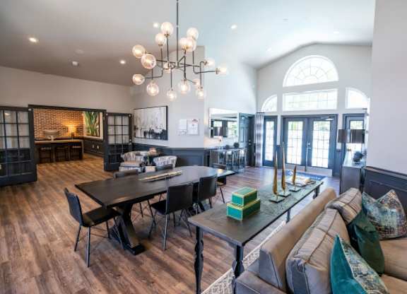 A modern living room with a black dining table and a grey sofa.