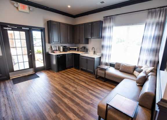 A kitchen with dark wood cabinets and a brown sofa.