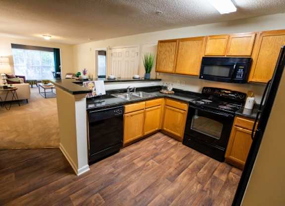 A kitchen with black appliances and wooden cabinets.