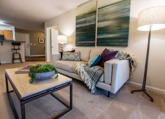 A living room with a couch, a coffee table, and a lamp.