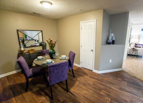 A dining room with a purple table and chairs.