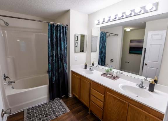 A bathroom with a white sink and a shower with a black and blue curtain.
