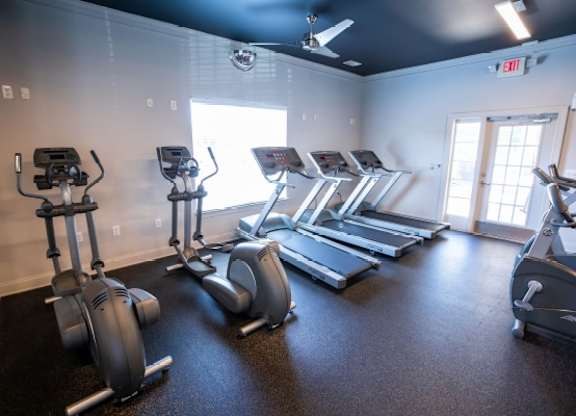 A gym with treadmills and elliptical machines.
