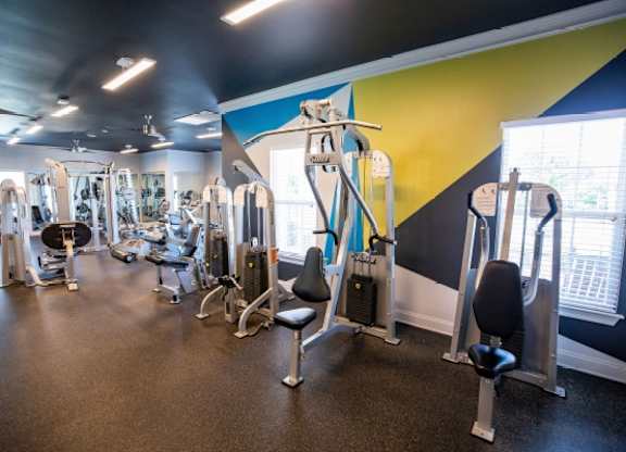 A gym with a variety of equipment including weights and machines.