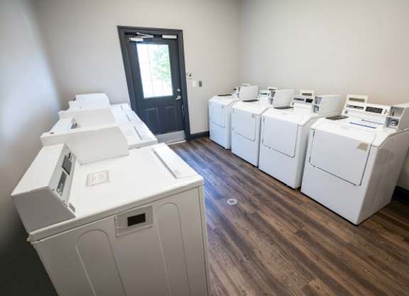 A room with a door and washing machines.
