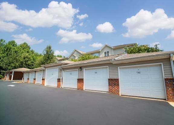 A row of garage doors in front of a house.