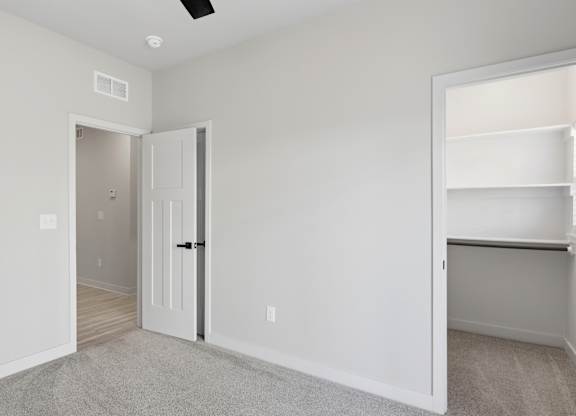 A room with a white door and a white shelf.