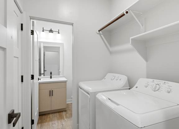 A white washing machine is in a small laundry room.