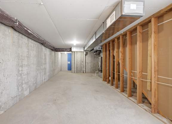 A long, empty hallway with a blue door at the end.