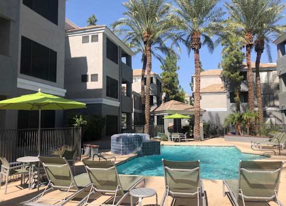 Dog-Friendly Garden-Style Apartments in Arcadia, AZ - The Ingleside Apartments - Swimming Pool with Hot Tub, Lounge Chairs, Shaded Seating, Gazebo, Palm Trees, and View of the Apartments.