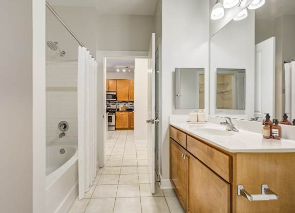 Apartments Near Joint Base Andrews - Tribeca at Camp Springs - A bathroom with a white sink and a mirror