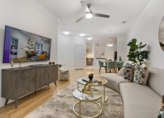 Apartments Near Washington D.C. - Tribeca at Camp Springs - A living room with a grey sofa, a coffee table, and a large