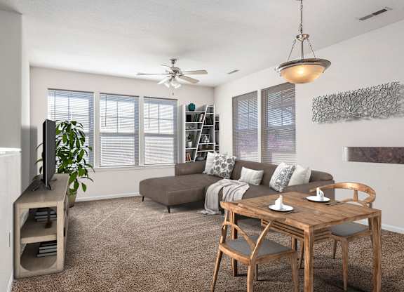 A living room with a brown couch, a wooden table, and a ceiling fan.