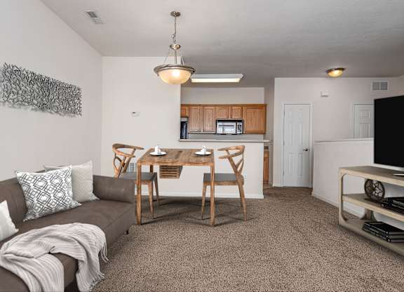 A living room with a brown couch and a wooden table.