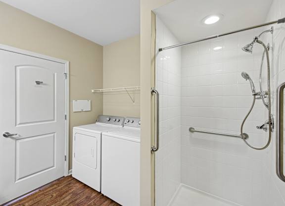 A white bathroom with a white door and a white washing machine.