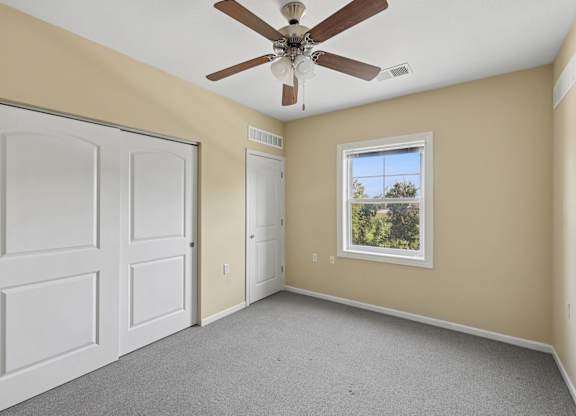 A room with a ceiling fan and a window.