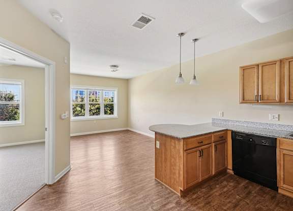 A kitchen with wooden cabinets and a black oven.